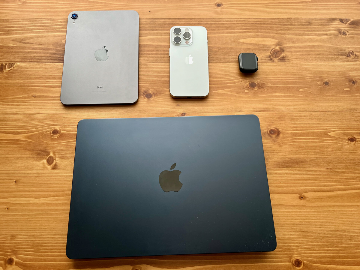 木の机に並べたiPad・iPhone・MacBook・Apple Watch。セールでの値下げが小さく、公式の初売りや学割と比べて買う時期を決めているApple製品