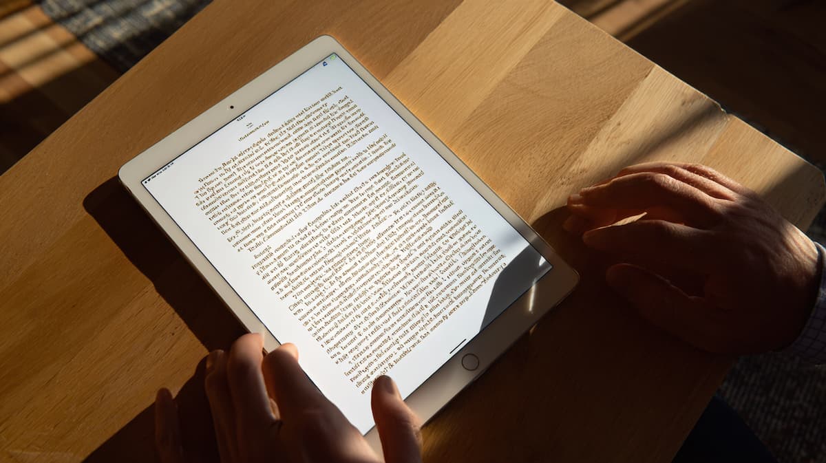木製テーブルの上に置かれた電子書籍を表示するタブレット