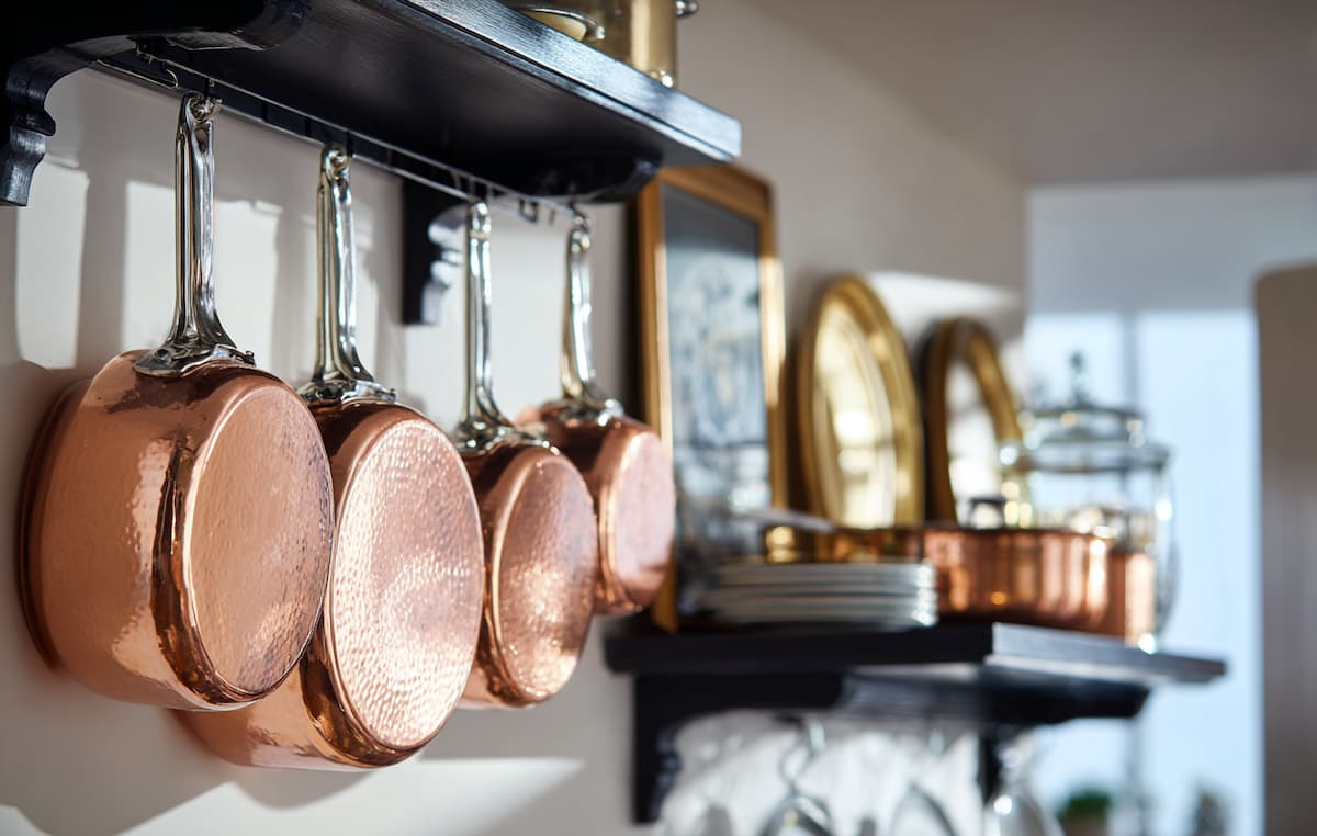 壁に貼り付けたフックにぶら下げる銅製の鍋