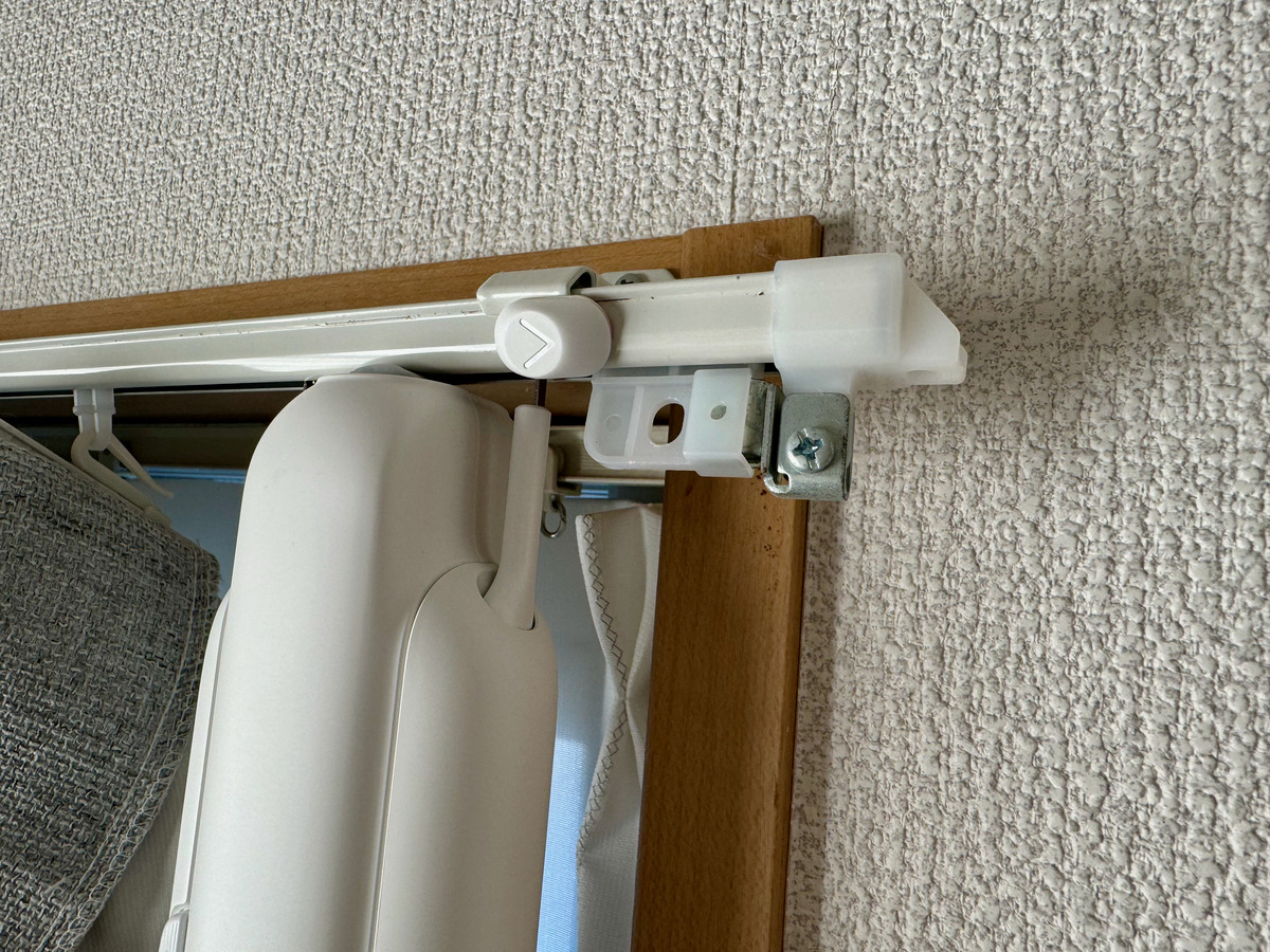 カーテンレールに取り付けたSwitchBotカーテンの本体と、レールの継ぎ目にある金具のアップ。伸縮式レールで引っかかる原因になる部分。