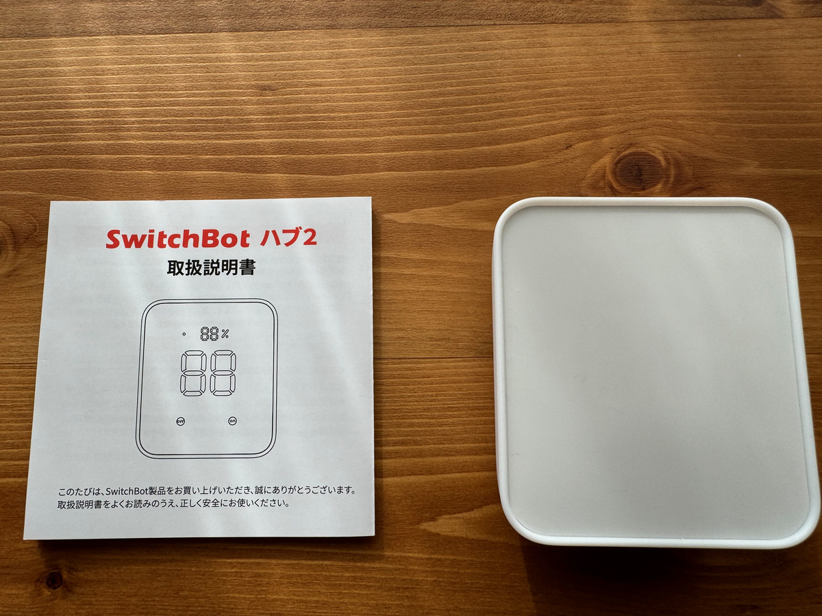 SwitchBotハブ2の取扱説明書と本体。購入直後の初期設定で危険を減らせることを示す写真。
